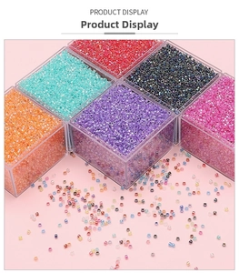 Close-up of colorful 2.5mm glass seed beads organized in clear plastic storage boxes