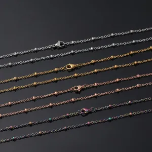 Détail de chaînes croisées en acier plaqué or 18 carats avec fermoirs homard en quatre couleurs
