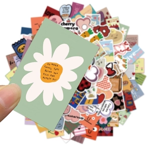 Close-up of green daisy sticker with quote among various colorful cute doodle decals