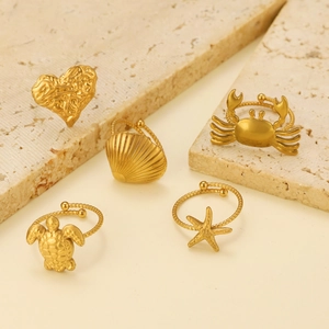 Close-up of 18K gold stainless steel rings set featuring sea shell and heart designs