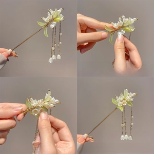 Detail of adjustable lily of the valley hair pin with white pearls and gold wire tassel