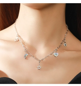 Detail of S925 silver necklace featuring rainbow, star, and heart charms on model