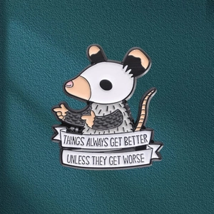 Cartoon opossum enamel pin with funny quote banners on dark green textured background