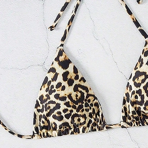 Detail of leopard print triangle bikini top with drawstring ties on marble background