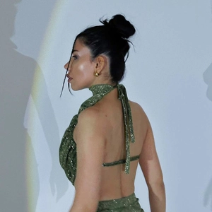 Detail of green sequin cowl neck top with backless design and shimmering texture