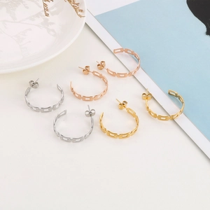 Detailed macro view of three pairs of hollow chain link C-shaped hoop earrings in gold finishes