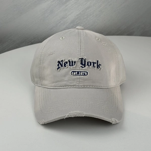 Detailansicht der grauen Vintage-Baseballkappe mit New York-Stickerei und modischen Riss-Effekten