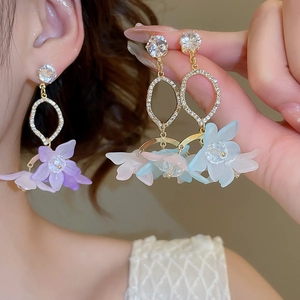 Close-up of flower petal drop earrings with zircons in purple, blue and pink tones