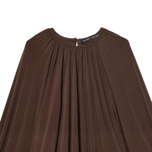 Women's dark brown pleated round neck blouse featuring loose lantern sleeves and draped hem