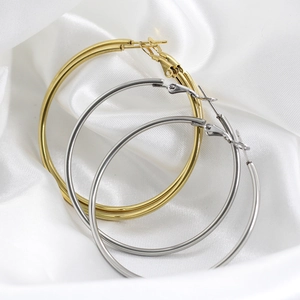 Detailed view of 18K gold and silver hoop earrings on white silk background