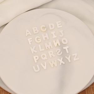 Original shell letter necklace with crystal beads and 26 A-Z alphabets on a marble tray