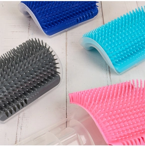 Detail view of corner cat groomer brushes in blue, pink, and grey silicone bristles