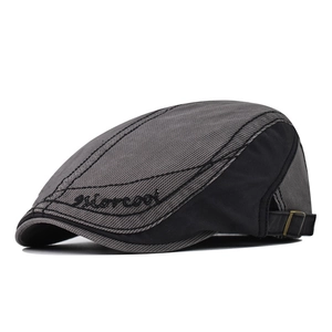 Detail view of cotton newsboy cap with morecooi embroidery and metal buckle strap