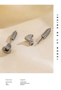 Detailed close-up of industrial style silver screw stud earrings in polished steel