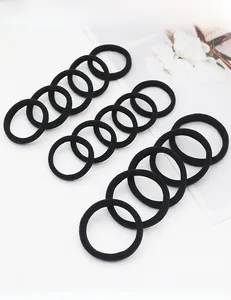 Detailed set of 12 black seamless elastic hair ties arranged on a minimalist white background