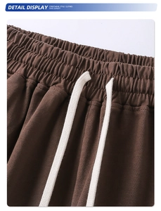 Detalle del pantalón de punto marrón con cintura elástica y cordones blancos