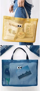 Detail view of large mesh beach tote bag with cartoon eye patches in blue and yellow