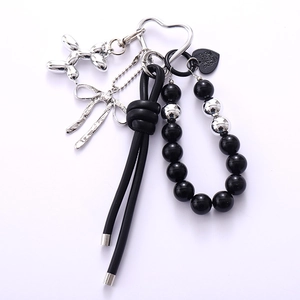Fashionable beaded keychain with silver balloon dog, leather bow, and acrylic bird nest charms