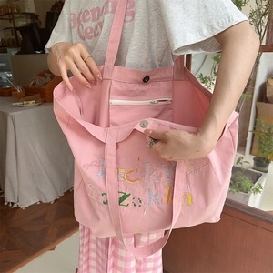 Détail du sac cabas en toile rose avec broderie florale et poche intérieure zippée