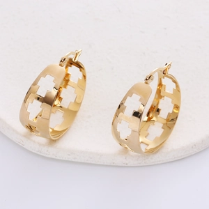 Polished 18K gold plated hollow geometric hoop earrings on a white stone base