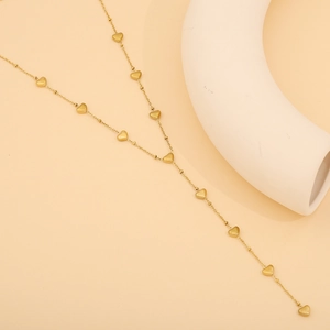 Détail des breloques en forme de cœur doré poli sur un collier fin en Y