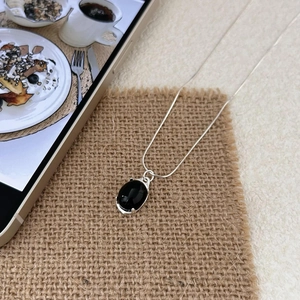 Vintage 925 silver snake chain necklace with oval black agate pendant on rustic linen cloth