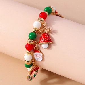 Close-up of Christmas beaded bracelet with Santa Claus and bell pendants on a pink stand