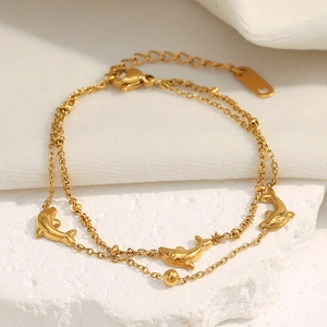 Detail of 18K gold plated dolphin pendants on a double-layer stainless steel bracelet