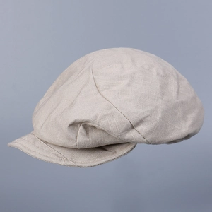 Detail view of the light beige linen newsboy cap showing its natural fabric texture