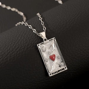 Detailed macro view of The Lovers tarot pendant with red heart and white enamel finish