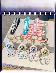 Detail of colorful astronaut keychains with silicone SPACE wristlets and metal finish masks