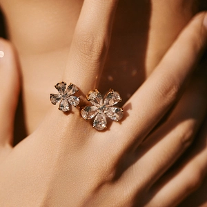 Close-up of elegant gold flower ring with sparkling zircon stones on a model's hand
