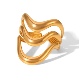 Detailed view of irregular geometric wave layers in gold plated stainless steel ring