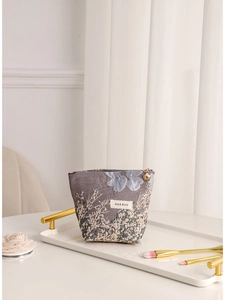 Elegant jacquard floral portable cosmetic bag featuring a gold flower zipper pull