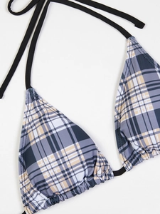 Close-up of a plaid bikini top with black string ties and subtle pleats on fabric