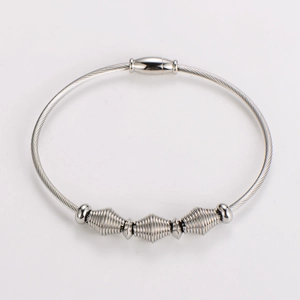 Macro view of silver wire cable bracelet with magnetic clasp and spiral charms