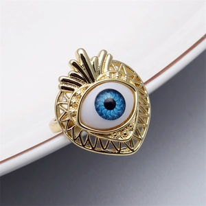 Macro view of gold-tone heart-shaped evil eye ring with blue resin eye detail