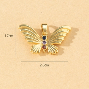 Macro shot of gold butterfly pendant with colorful gemstones and 1.7x2.6cm dimensions