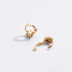 Close-up of gold flower huggie hoop earrings with micro cubic zirconia details