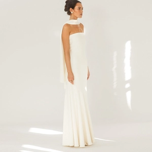 Close-up of elegant white strapless maxi dress with matching long neck scarf detail