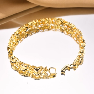 Detailed macro of gold-plated hollow heart and X-shaped links with polished finish