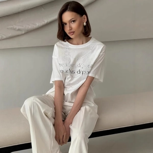 Detail of white cotton T-shirt featuring elegant pearl necklace print and lettering