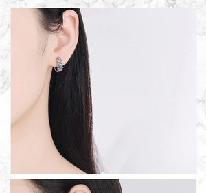 Close-up of elegant silver hoop earrings with four multi-colored zircon gemstone inlays
