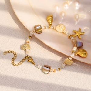 Detail of 18K gold plated ocean series bracelet with shell and starfish charms