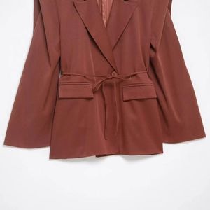 Brown mid-length notched lapel blazer with waist tie and flap pockets on white background