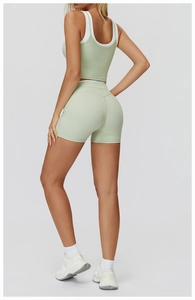 Detail view of the seamless green yoga set showing contrast white trim and racerback design
