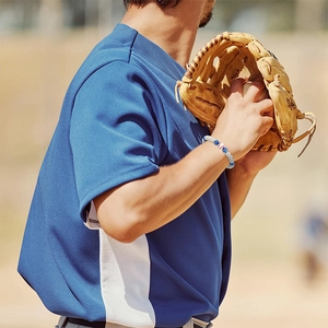 Close-up of blue white and red baseball themed beaded bracelet worn by an athlete