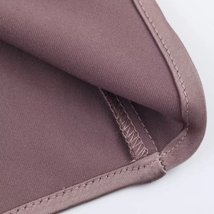 Detailed close-up of fine hem stitching and soft texture on dusty pink satin midi dress