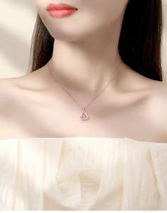 Detail of rose gold clover necklace with sparkling white moissanite on female model neck