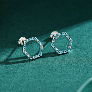 S925 sterling silver hexagonal stud earrings with blue turquoise inlay on green background